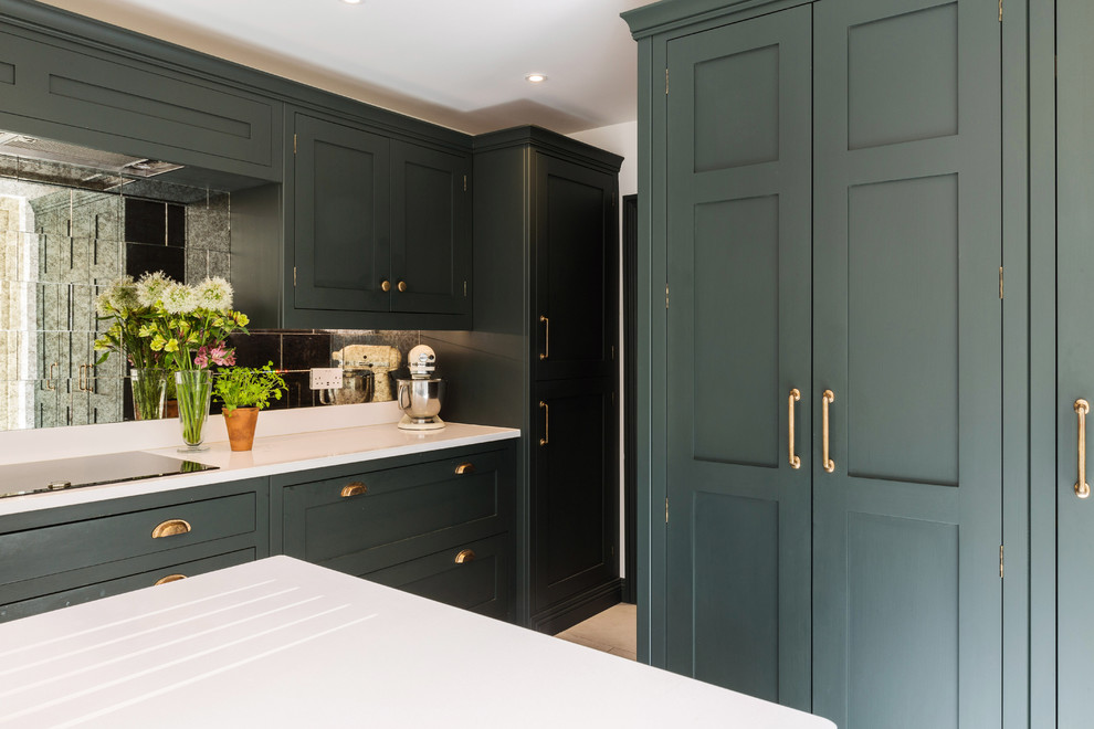 This is an example of a large traditional l-shaped eat-in kitchen in London with an integrated sink, shaker cabinets, green cabinets, quartzite benchtops, metallic splashback, glass tile splashback, panelled appliances, limestone floors, with island, white floor and white benchtop.
