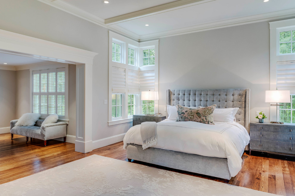 Photo of a large transitional master bedroom in Boston with grey walls, linoleum floors, a standard fireplace, a stone fireplace surround and beige floor.