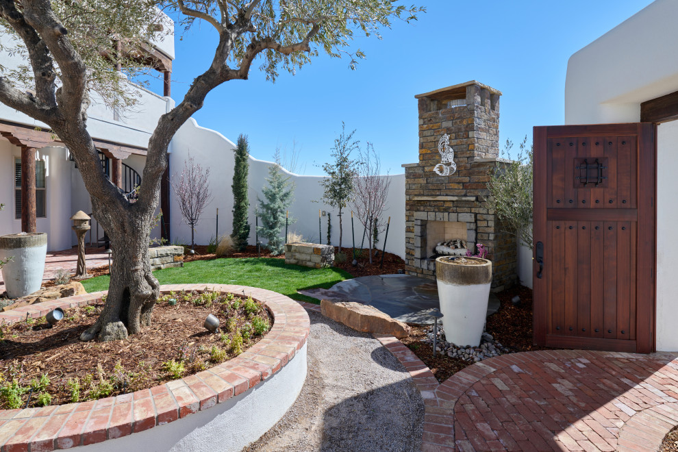 Design ideas for a small eclectic drought-tolerant and full sun courtyard brick landscaping in Other with a fireplace.