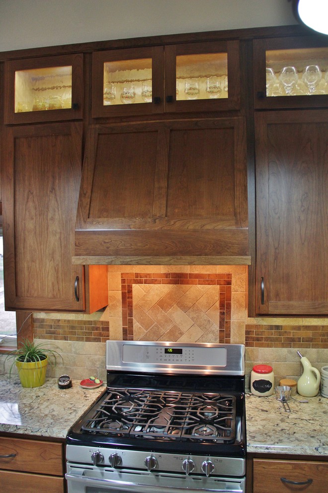 Inspiration for a mid-sized transitional galley ceramic tile enclosed kitchen remodel with an undermount sink, shaker cabinets, medium tone wood cabinets, quartz countertops, beige backsplash, stone tile backsplash, stainless steel appliances and a peninsula