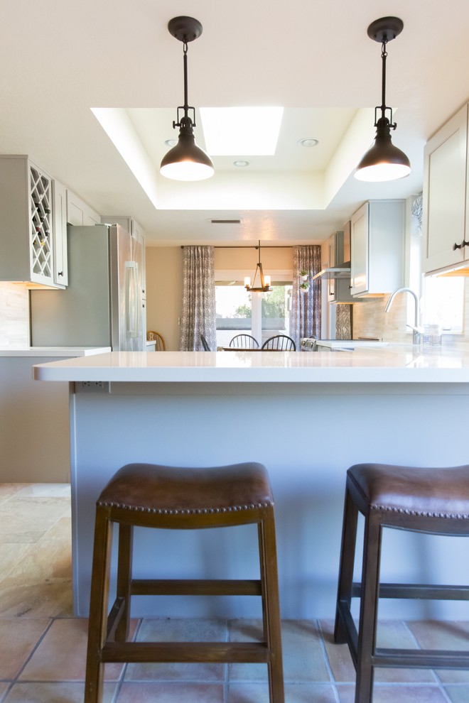 Mid-sized transitional u-shaped porcelain tile kitchen photo in Phoenix with a farmhouse sink, shaker cabinets, gray cabinets, quartz countertops, gray backsplash, porcelain backsplash, stainless steel appliances and a peninsula