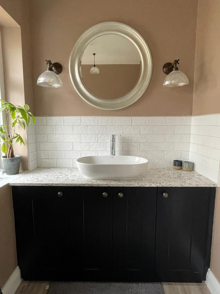 Photo of a mid-sized traditional kids bathroom with shaker cabinets, black cabinets, a shower/bathtub combo, a two-piece toilet, white tile, ceramic tile, pink walls, wood-look tile, a vessel sink, marble benchtops, grey floor, multi-coloured benchtops, a single vanity, a built-in vanity and a claw-foot tub.