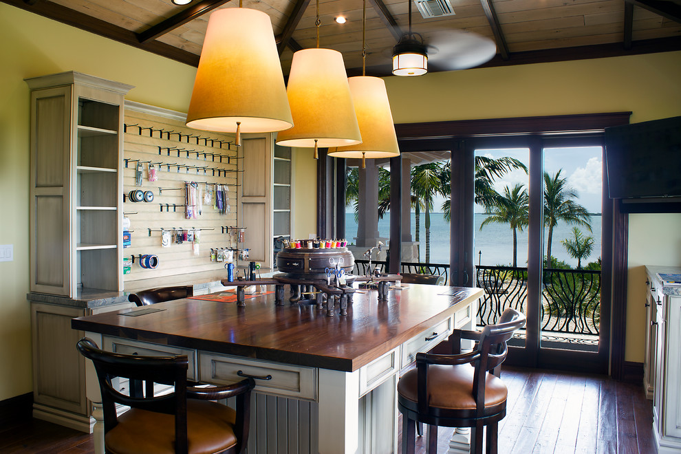 Tropical craft room in Miami with yellow walls, dark hardwood floors, no fireplace, a freestanding desk and brown floor.