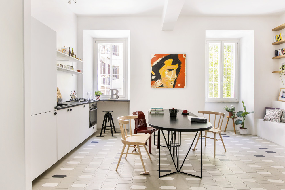 Kleine Eklektische Küche mit buntem Boden, Einbauwaschbecken, weißen Schränken, Porzellan-Bodenfliesen und schwarzer Arbeitsplatte in Rom