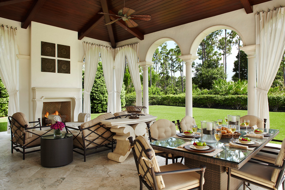 This is an example of a mid-sized mediterranean backyard verandah in Miami with a fire feature and concrete pavers.