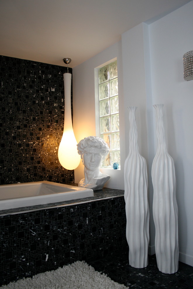 Inspiration for an eclectic bathroom in Toronto with a drop-in tub, black tile and mosaic tile.