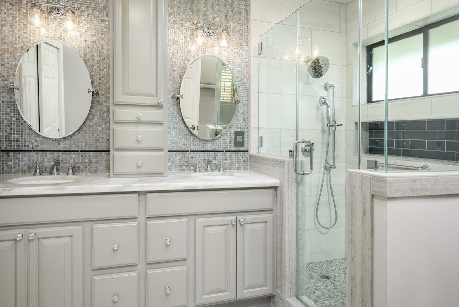 Large transitional master gray tile and mosaic tile laminate floor and beige floor corner shower photo with raised-panel cabinets, gray cabinets, beige walls, an undermount sink, quartzite countertops, a hinged shower door and white countertops
