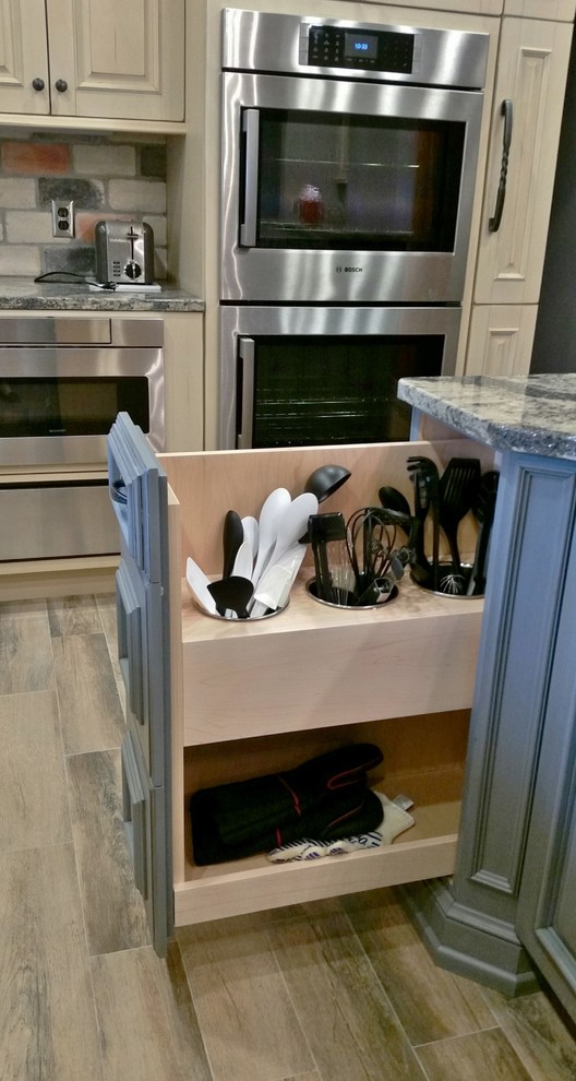 Large light wood floor kitchen photo with raised-panel cabinets, blue cabinets, quartzite countertops, multicolored backsplash, subway tile backsplash, stainless steel appliances and an island