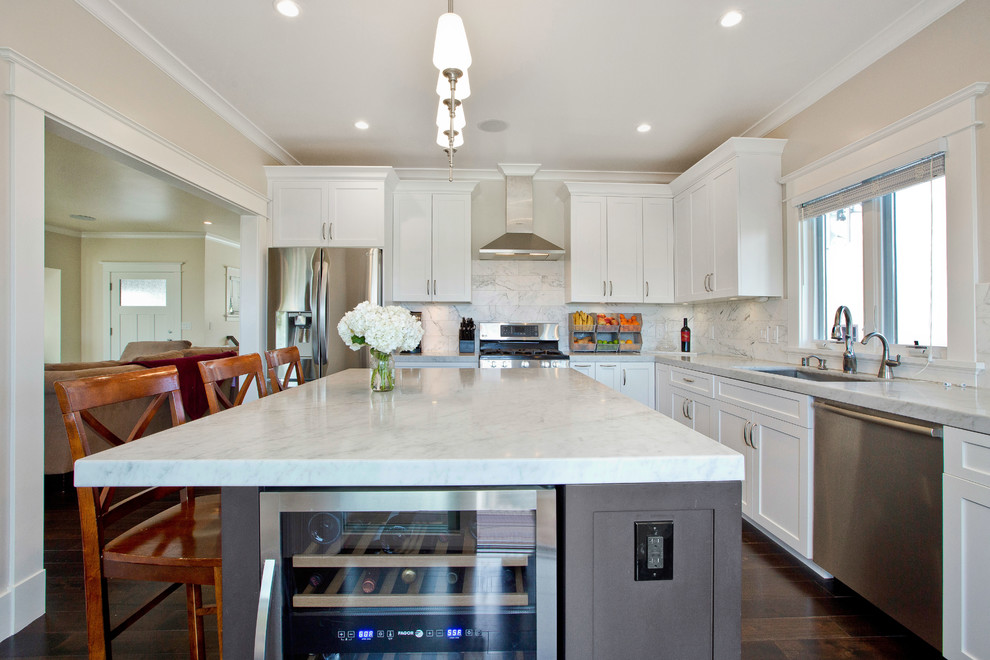 Mid-sized arts and crafts l-shaped separate kitchen in San Francisco with an undermount sink, white cabinets, marble benchtops, white splashback, stone slab splashback, stainless steel appliances, dark hardwood floors, with island, brown floor, white benchtop and raised-panel cabinets.