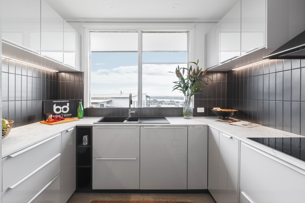 Small eclectic u-shaped kitchen in Melbourne with a double-bowl sink, black splashback, ceramic splashback, black appliances and with island.