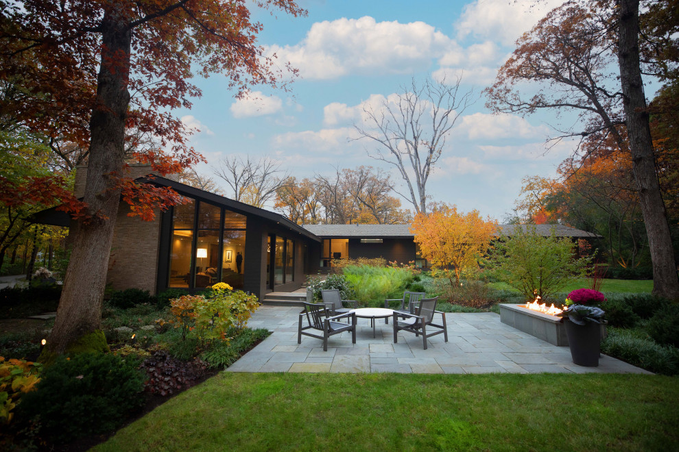 Design ideas for an expansive retro back partial sun garden for summer in Chicago with a fire feature and natural stone paving.