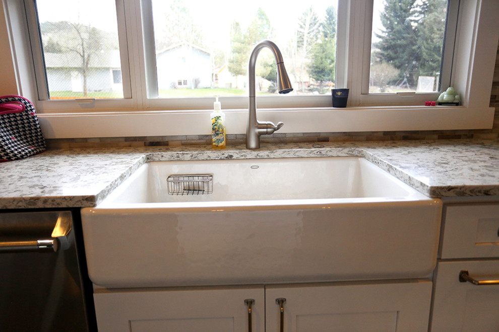 Kitchen - transitional kitchen idea with a farmhouse sink, shaker cabinets, white cabinets, granite countertops and stainless steel appliances