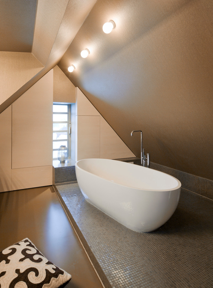 Inspiration for a small modern bathroom in Stuttgart with vinyl floors, beige floor, flat-panel cabinets, light wood cabinets, a freestanding tub, a two-piece toilet, brown tile, mosaic tile, a trough sink and wood benchtops.