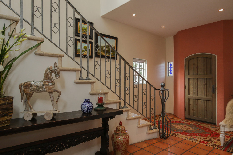 На фото: прямая лестница в средиземноморском стиле с металлическими перилами