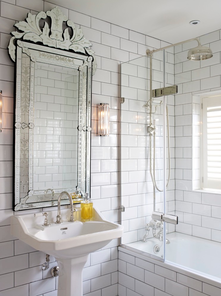 Transitional bathroom in London with a pedestal sink, a shower/bathtub combo, white tile, subway tile and white walls.