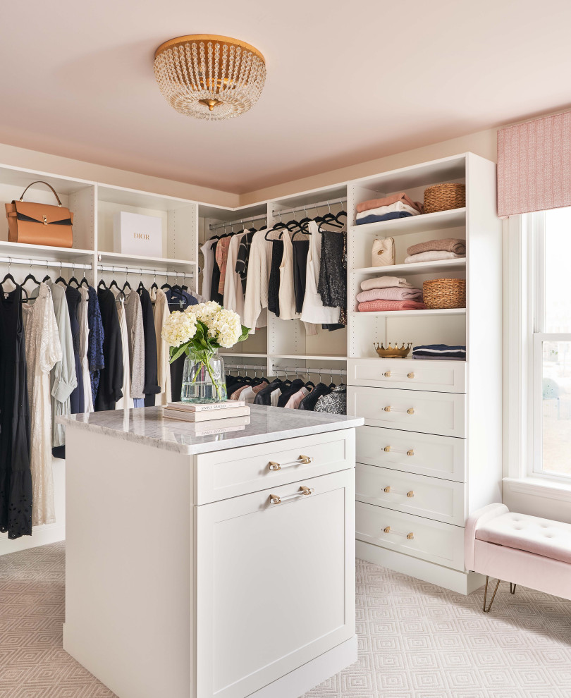 Aménagement d'un grand dressing bord de mer neutre avec un placard à porte shaker, des portes de placard blanches, moquette et un sol beige.