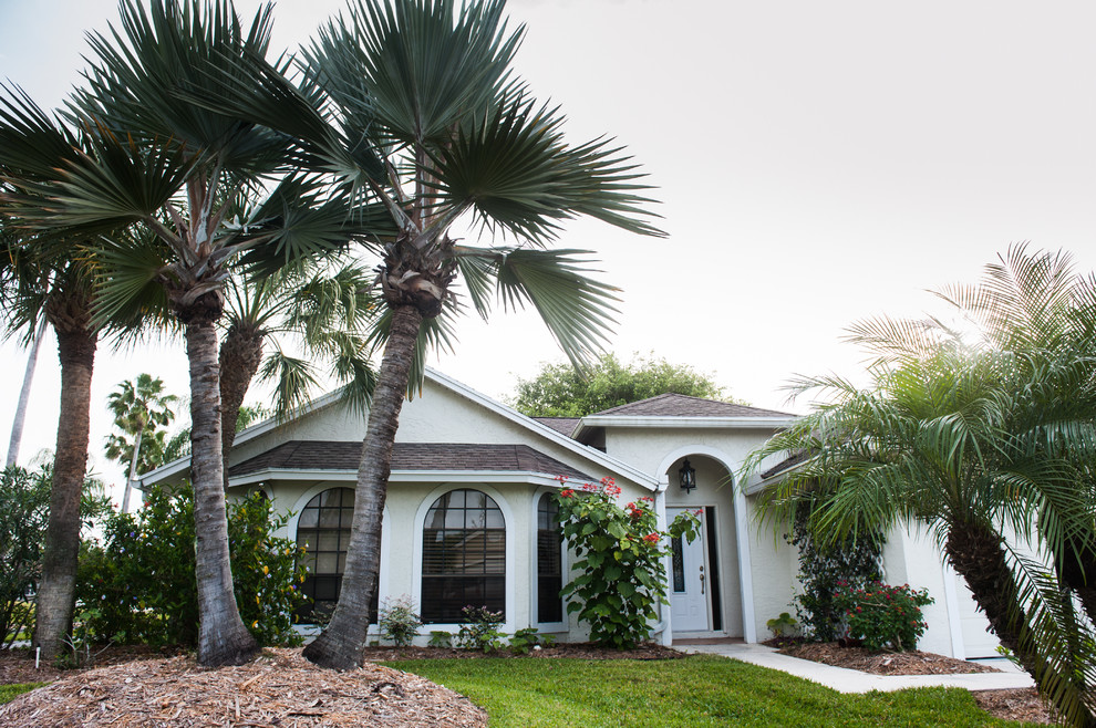 Photo of a large beach style one-storey stucco white exterior in Miami with a gable roof.