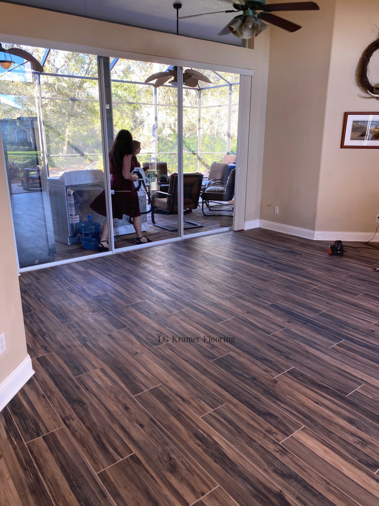 Large living room in Tampa with brown floor and porcelain floors.