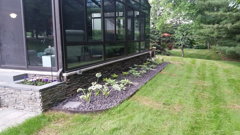 Photo of a mid-sized traditional backyard shaded garden in Detroit with a container garden and gravel.