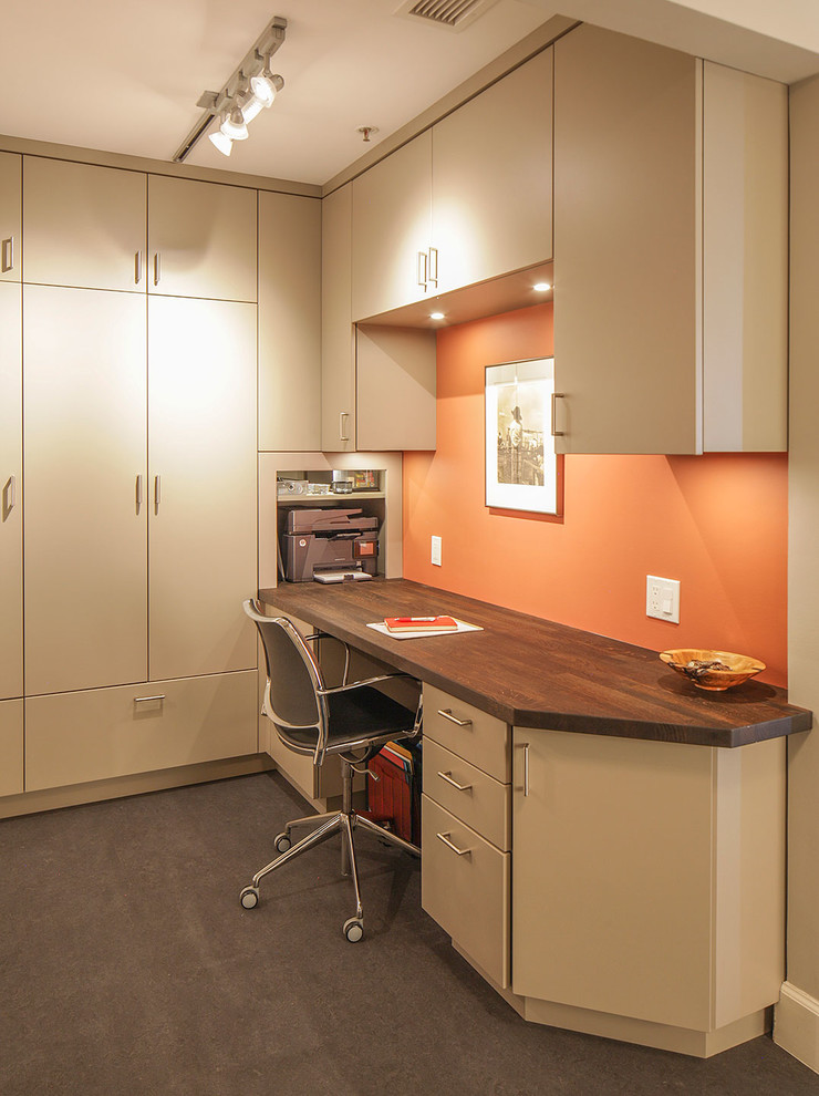 This is an example of a small contemporary study room in San Francisco with orange walls, linoleum floors, no fireplace, a built-in desk and grey floor.