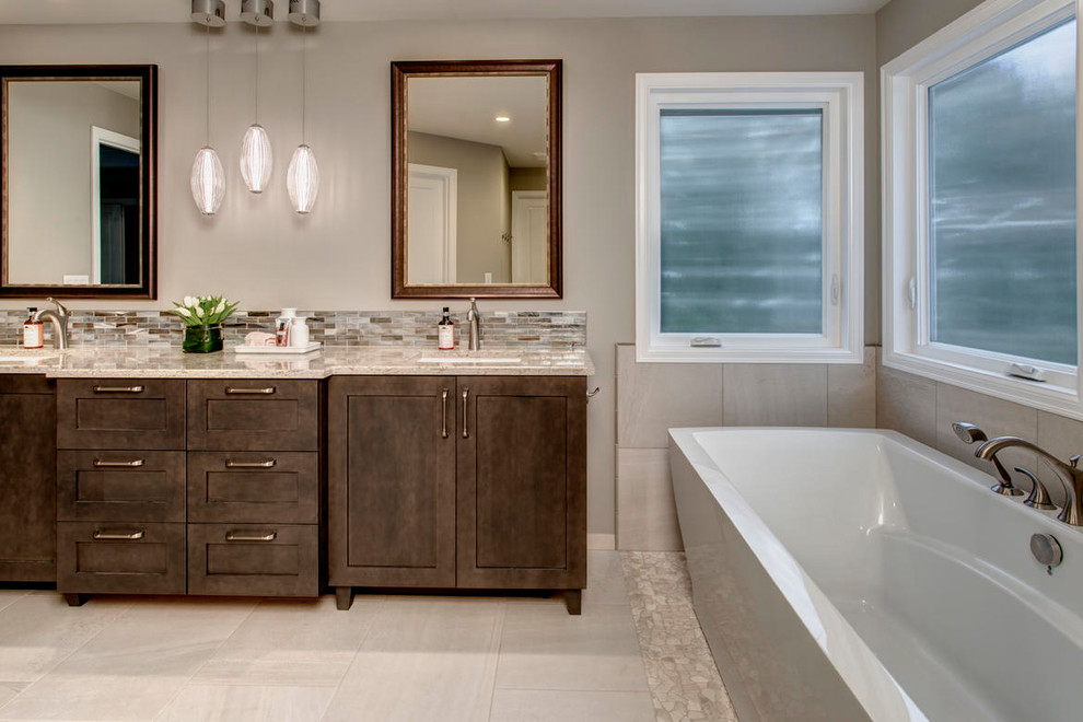 Large transitional master multicolored tile and matchstick tile pebble tile floor freestanding bathtub photo in Seattle with shaker cabinets, dark wood cabinets, a two-piece toilet, beige walls, an undermount sink and quartz countertops