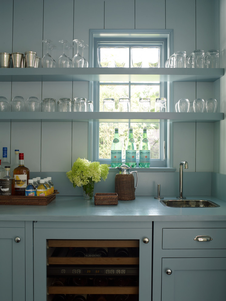 Inspiration for a large contemporary single-wall wet bar remodel in New York with a drop-in sink, beaded inset cabinets, blue cabinets, solid surface countertops, blue backsplash and blue countertops