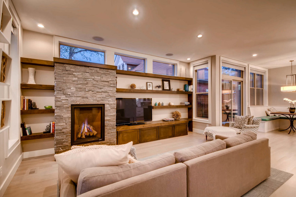 Trendy open concept light wood floor family room photo in Denver with a standard fireplace, a stacked stone fireplace and a media wall