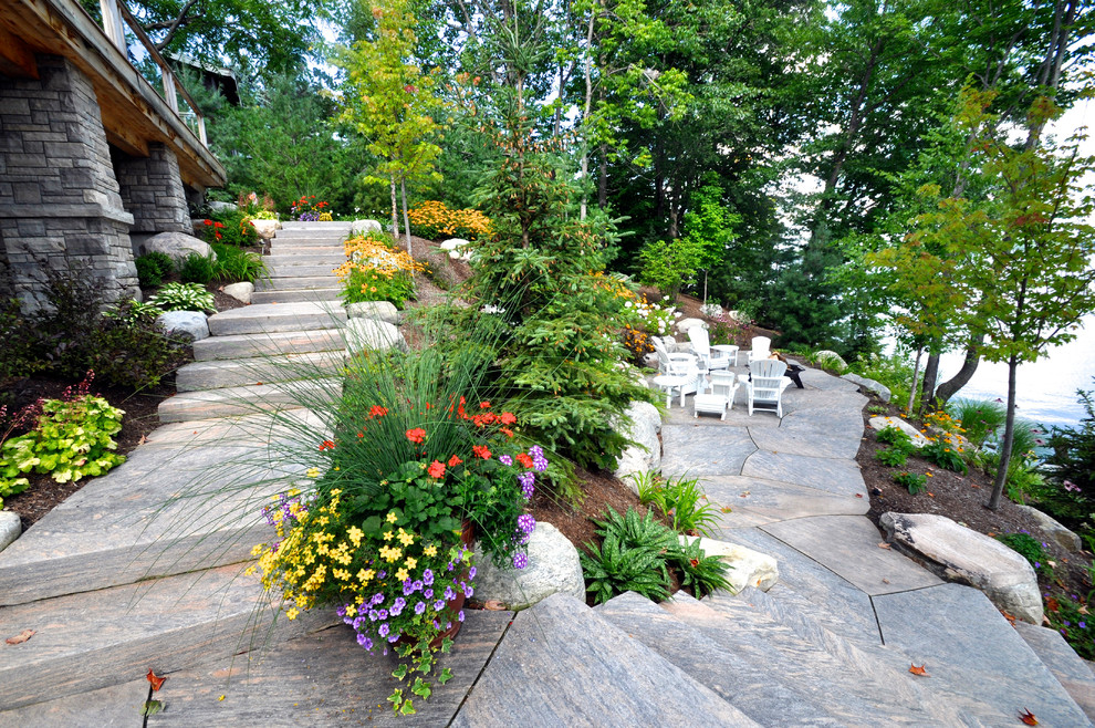 Arts and crafts sloped garden in Toronto with a garden path for summer.