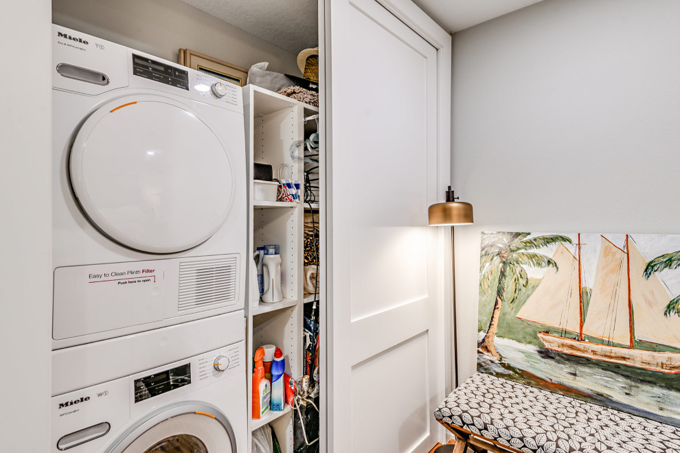 Laundry closet - small coastal laundry closet idea in Tampa with a stacked washer/dryer