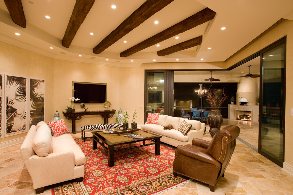 Design ideas for a large mediterranean open concept living room in Orlando with beige walls, travertine floors, a standard fireplace, a tile fireplace surround and a wall-mounted tv.