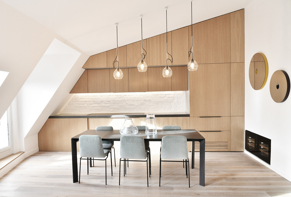 Contemporary eat-in kitchen in Paris with light wood cabinets, concrete benchtops, grey benchtop, flat-panel cabinets, white splashback, light hardwood floors and beige floor.