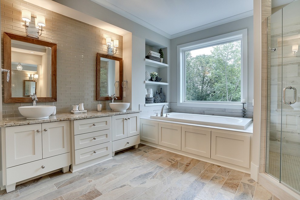Photo of a large transitional master bathroom in Minneapolis with a vessel sink, recessed-panel cabinets, white cabinets, marble benchtops, a drop-in tub, an alcove shower, brown tile, glass tile, grey walls and ceramic floors.