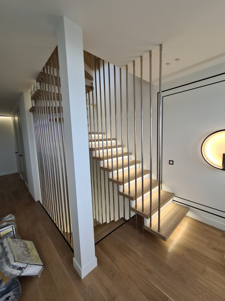Imagen de escalera en U contemporánea grande con escalones de madera, contrahuellas de madera, barandilla de metal y ladrillo