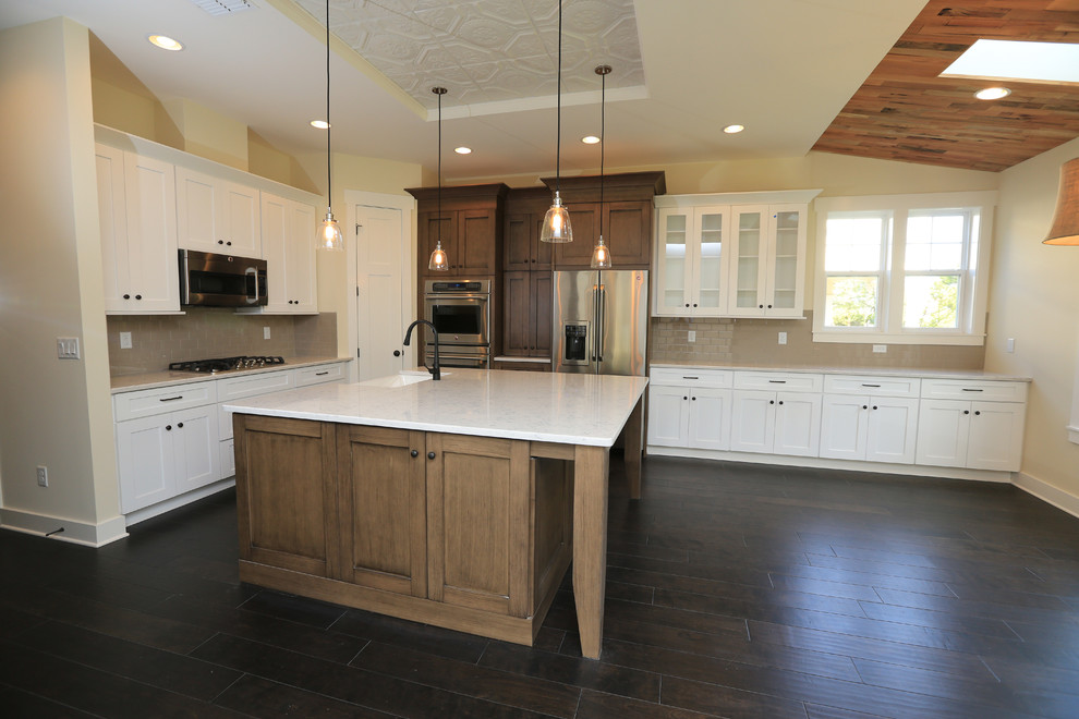 This is an example of a traditional l-shaped eat-in kitchen in Jacksonville with a farmhouse sink, shaker cabinets, quartz benchtops, brown splashback, subway tile splashback and stainless steel appliances.