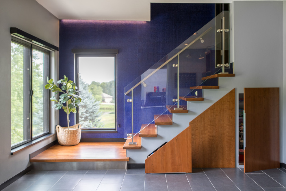 На фото: прямая лестница среднего размера в стиле модернизм с деревянными ступенями, стеклянными перилами и подступенками из плитки с