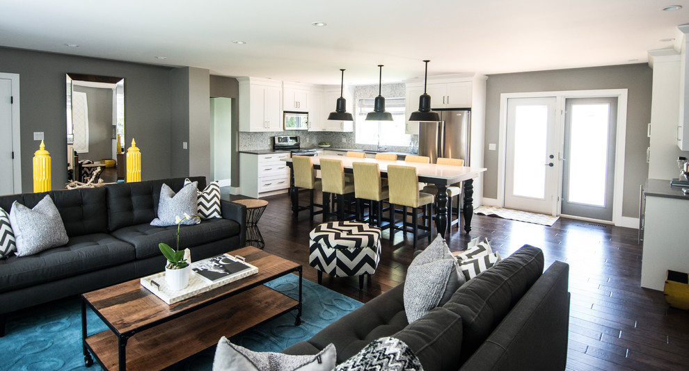 This is an example of a transitional living room in Calgary with grey walls and dark hardwood floors.