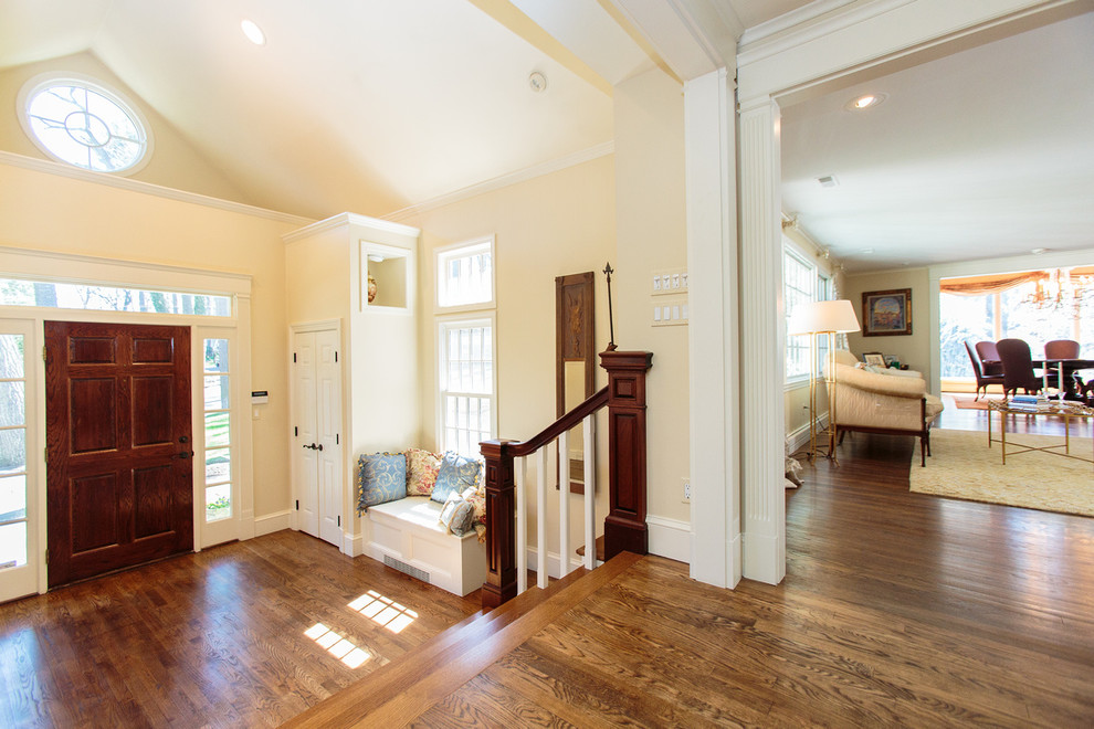 This is an example of a traditional foyer in Boston with beige walls, medium hardwood floors, a single front door and a dark wood front door.