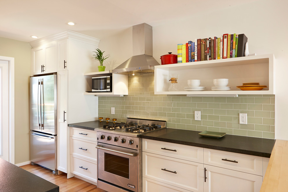 Design ideas for a transitional galley kitchen in San Francisco with recessed-panel cabinets, white cabinets, green splashback, glass tile splashback and stainless steel appliances.