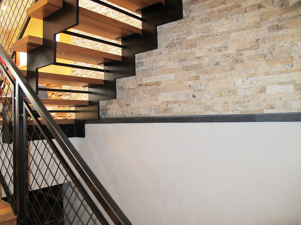 Photo of a large contemporary wood floating staircase in Denver with open risers and metal railing.