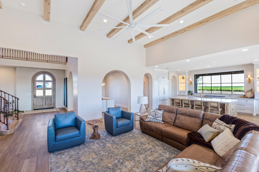Great Room with Curved Staircase and Blue Accent Chairs | Tuscan Farmhouse