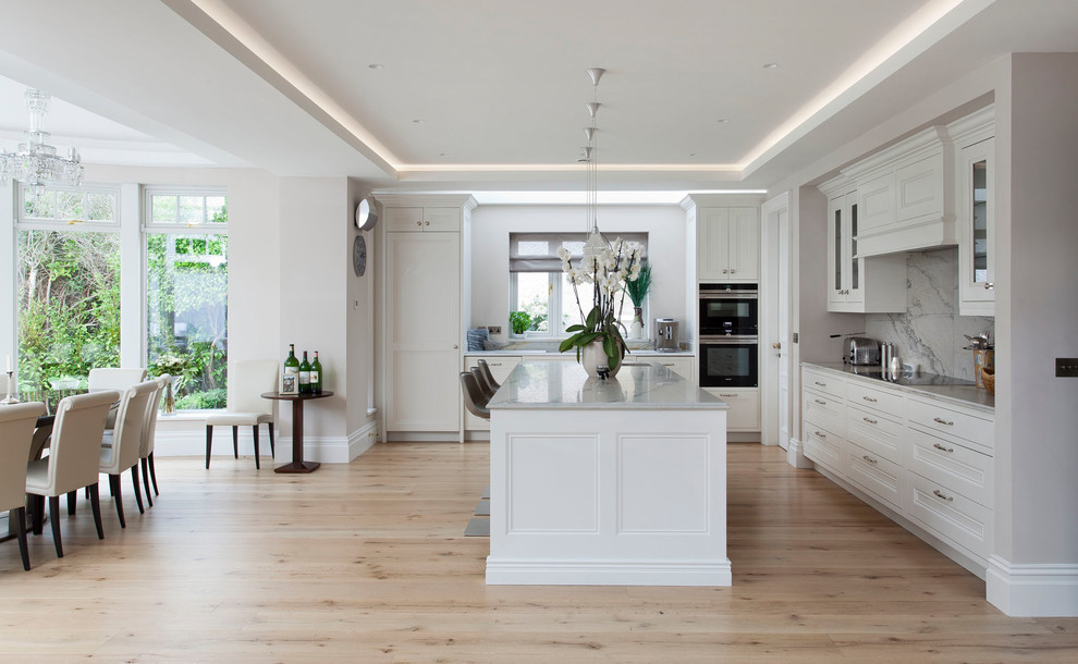 Inspiration for a large transitional kitchen in Other with a drop-in sink, beaded inset cabinets, white cabinets, marble benchtops, white splashback, marble splashback, stainless steel appliances, light hardwood floors, with island and yellow benchtop.