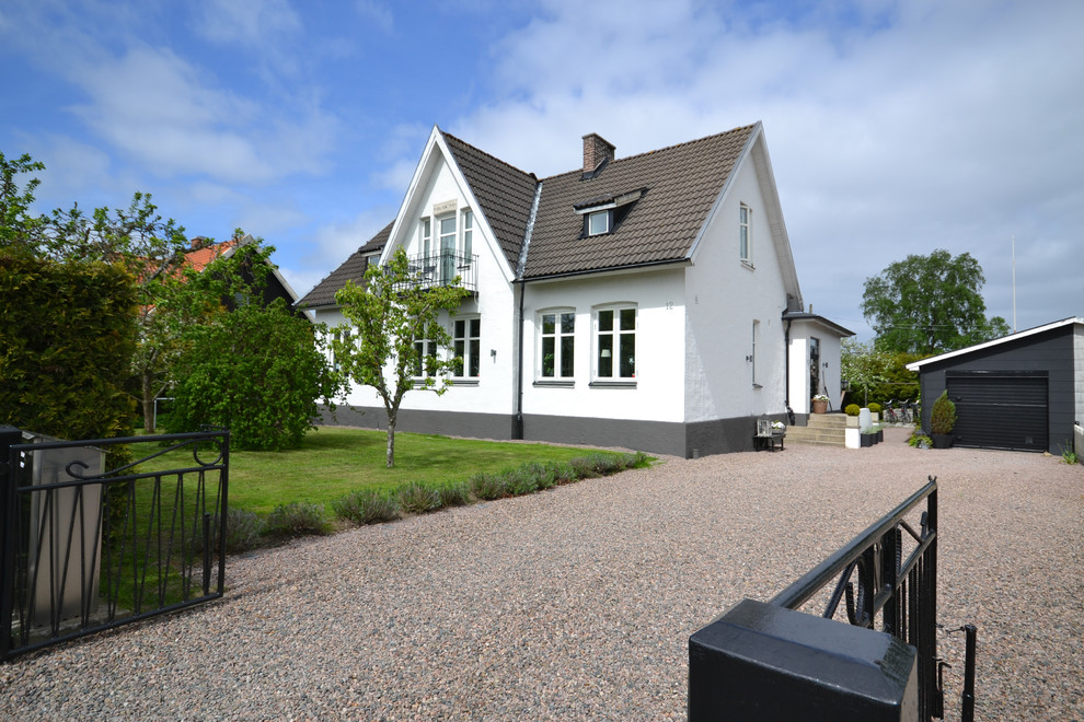 Inspiration for a traditional two-storey white house exterior in Malmo with a gable roof and a tile roof.