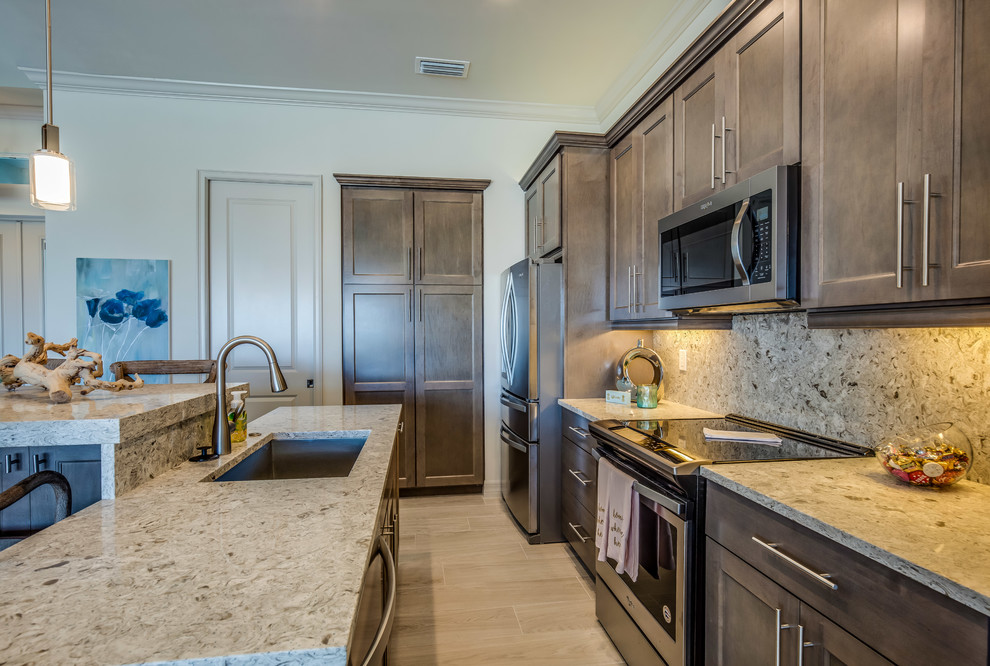 Inspiration for a transitional ceramic tile and gray floor kitchen remodel with a drop-in sink, flat-panel cabinets, gray cabinets, quartz countertops, stainless steel appliances and an island