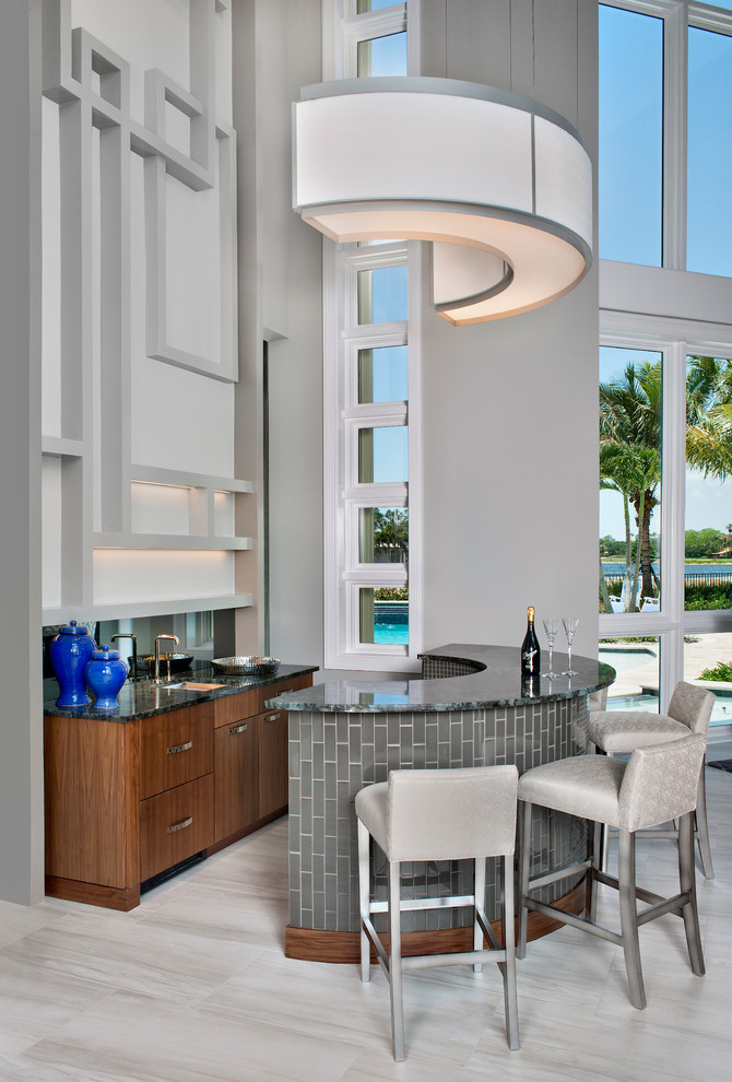 This is an example of a mid-sized contemporary u-shaped seated home bar in Miami with flat-panel cabinets, medium wood cabinets and an undermount sink.