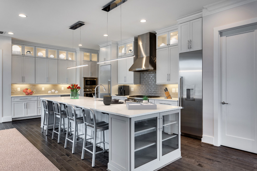 Large transitional l-shaped dark wood floor open concept kitchen photo in DC Metro with an undermount sink, shaker cabinets, white cabinets, quartzite countertops, gray backsplash, glass tile backsplash, stainless steel appliances and an island