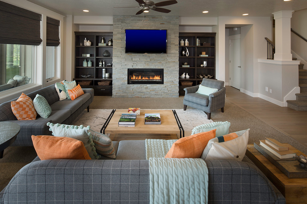 Transitional open concept living room in Boise with grey walls, medium hardwood floors, a ribbon fireplace, a stone fireplace surround and a wall-mounted tv.