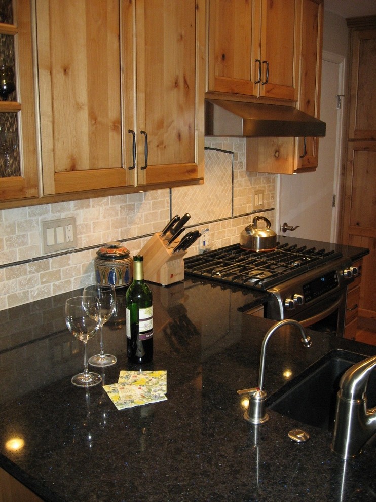 Example of a mid-sized mountain style l-shaped dark wood floor eat-in kitchen design in Denver with a double-bowl sink, shaker cabinets, light wood cabinets, quartzite countertops, beige backsplash, stone tile backsplash, stainless steel appliances and a peninsula