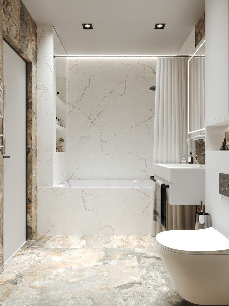 Bild på ett en-suite badrum, med vita skåp, ett undermonterat badkar, en dusch/badkar-kombination, en vägghängd toalettstol, vit kakel, porslinskakel, klinkergolv i porslin, ett väggmonterat handfat och dusch med duschdraperi