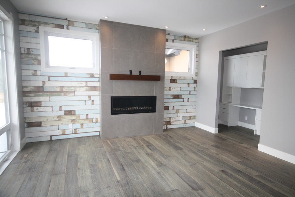 Large beach style open concept living room in Calgary with medium hardwood floors, a hanging fireplace and a tile fireplace surround.
