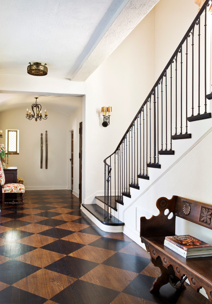 Photo of a mediterranean entryway in Los Angeles with white walls, painted wood floors and multi-coloured floor.